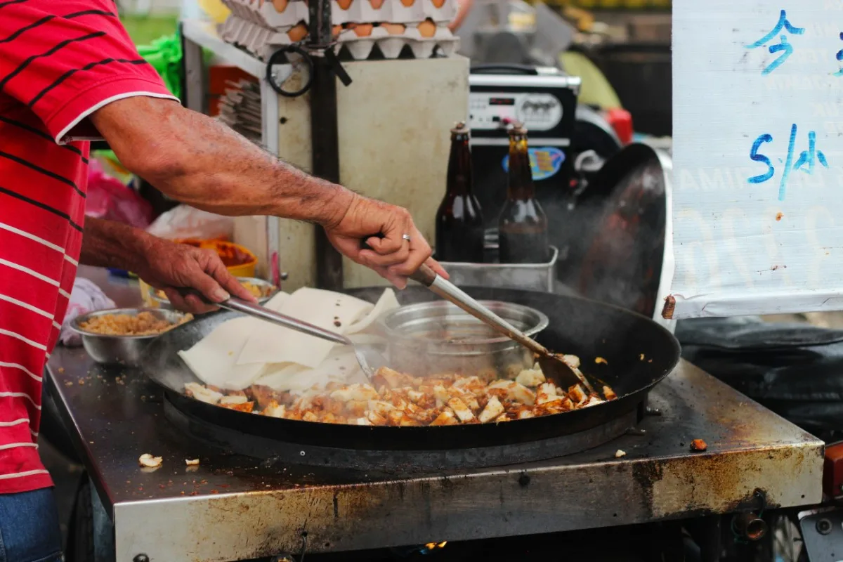 man cooking street food in penang